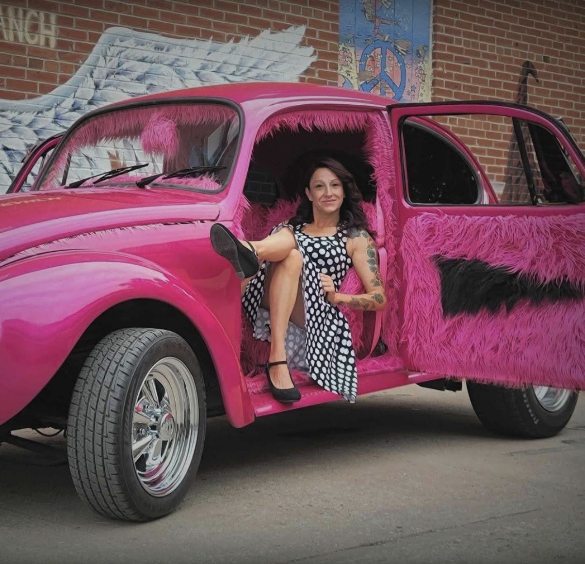Tabitha in a bright pink vintage car